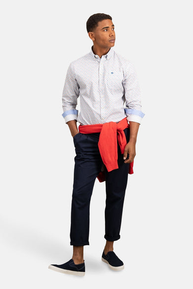 Chemise à manches longues bleue de FYNCH-HATTON avec motif imprimé et un pull rouge noué.
