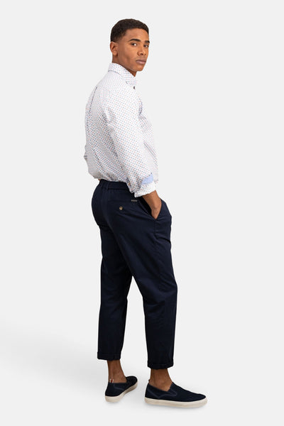 Chemise à manches longues bleue de FYNCH-HATTON, avec un motif à pois, portée avec un pantalon bleu marine.
