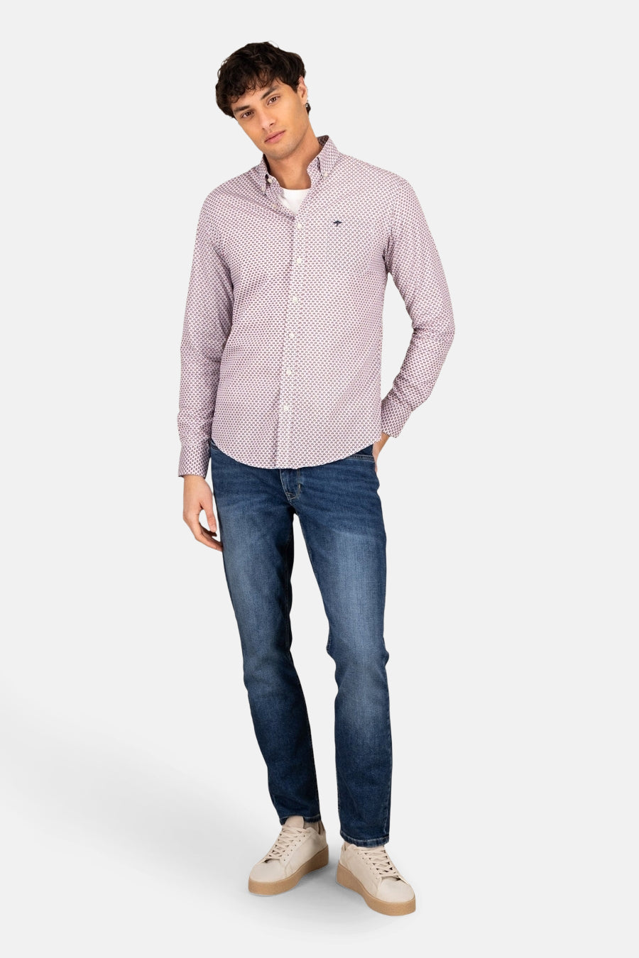 Chemise à manches longues rouge de FYNCH-HATTON, à motif imprimé, portée avec un jean bleu et des baskets beiges.