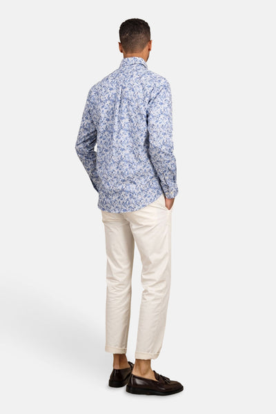 Chemise à manches longues bleue de FYNCH-HATTON avec motif fleuri, portée avec un pantalon clair et des mocassins.
