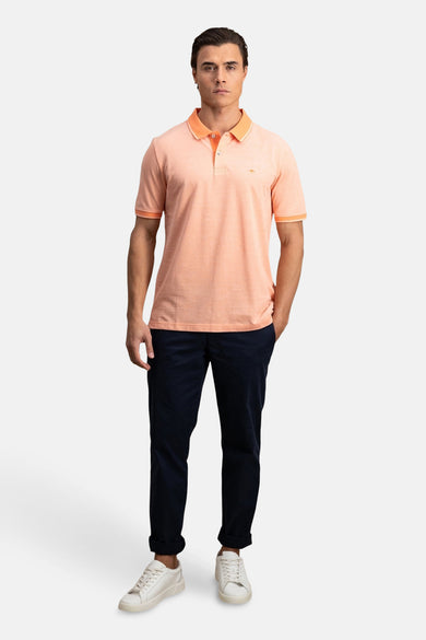 Oranje poloshirt met korte mouwen van FYNCH-HATTON, gedragen met een opgerolde marineblauwe chino en witte sneakers.