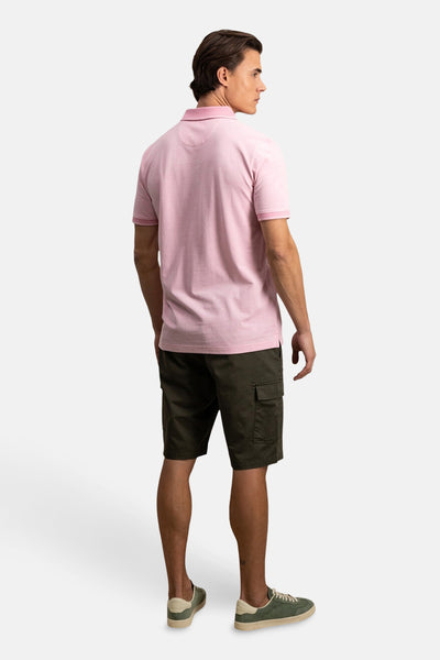 Polo rose à manches courtes de FYNCH-HATTON, porté avec un short cargo kaki et des baskets vert olive.