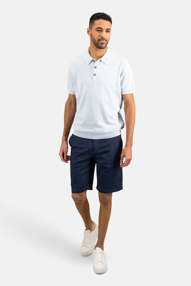 Lichtblauw poloshirt met korte mouwen van FYNCH-HATTON, gedragen met een spijkerbroekshort en witte sportschoenen.