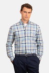 Chemise bleue à carreaux de FYNCH-HATTON, portée avec un pantalon bleu marine et une ceinture tressée.
