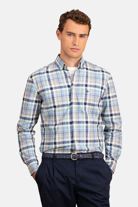 Chemise bleue à carreaux de FYNCH-HATTON, portée avec un pantalon bleu marine et une ceinture tressée.

