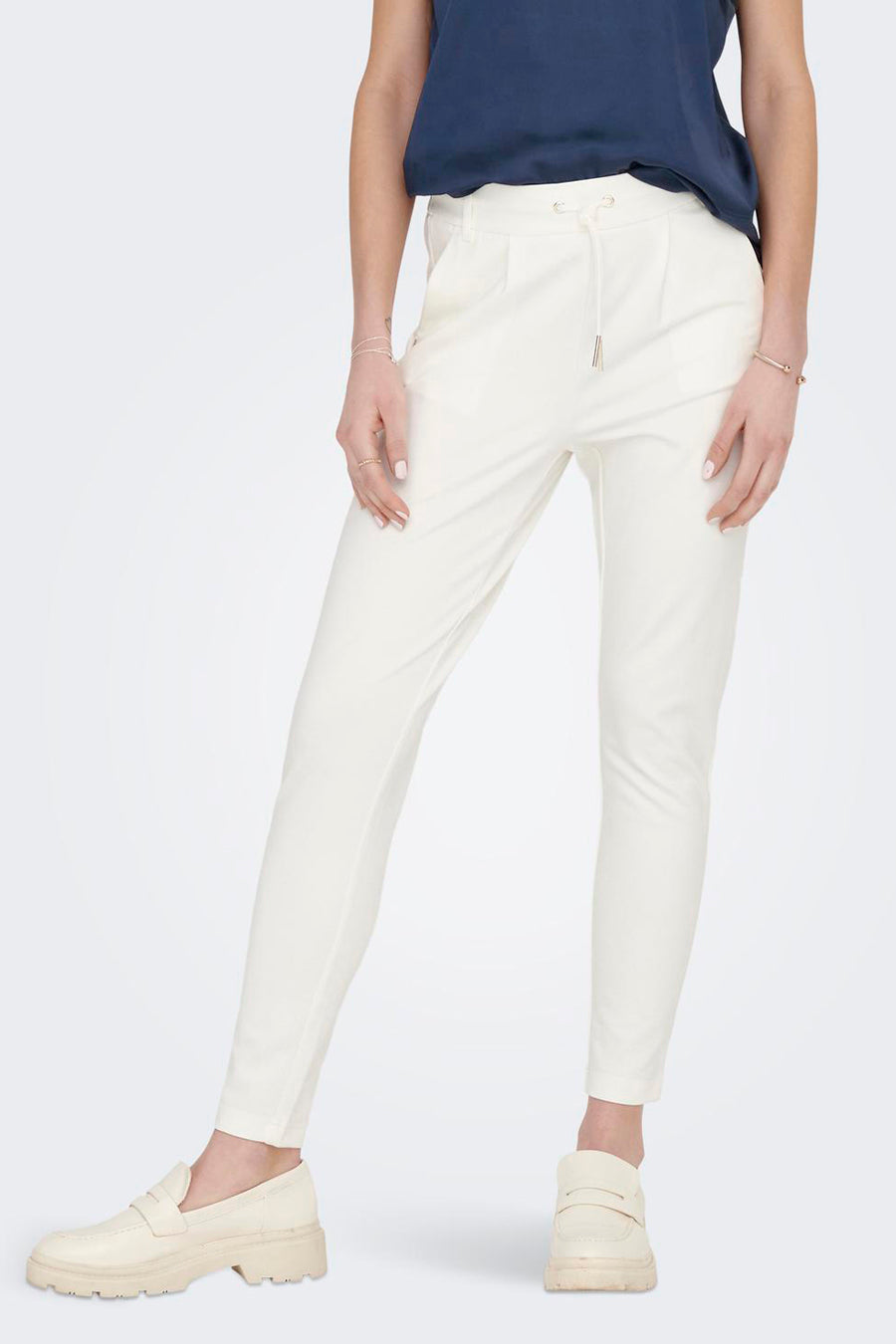 Ecru chino van ONLY, met elastiek in de taille en gedragen met een marineblauw T-shirt.