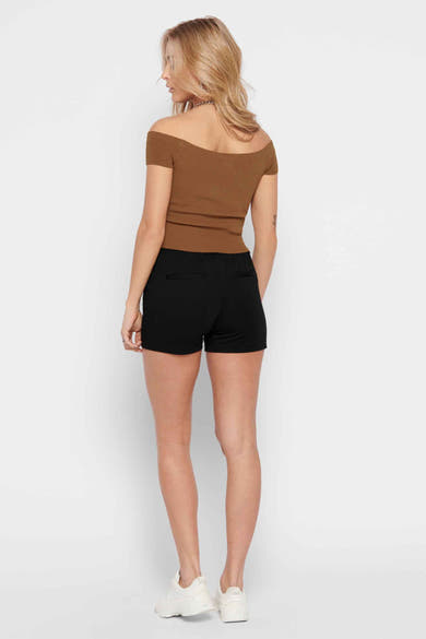 Korte zwarte short van ONLY, gedragen met een bruine off-shoulder top en witte sneakers.