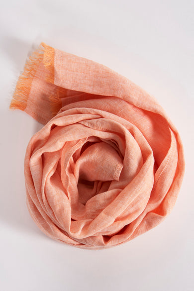 Foulard orange de FYNCH-HATTON, disposé en spirale, avec des franges décoratives.