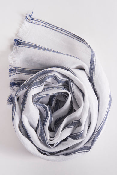 Foulard blanc à rayures bleues par FYNCH-HATTON, enroulé en forme de rose, avec des franges bleues.