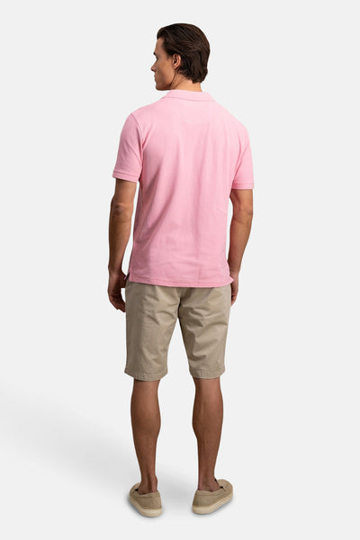 Polo rose à manches courtes de FYNCH-HATTON, porté avec un short beige et des chaussures décontractées.