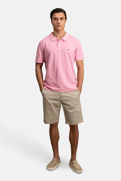 Polo à manches courtes rose de FYNCH-HATTON porté avec un short beige et des chaussures décontractées.