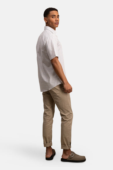 Chemise à manches courtes rouge de FYNCH-HATTON avec un motif géométrique et un pantalon beige.