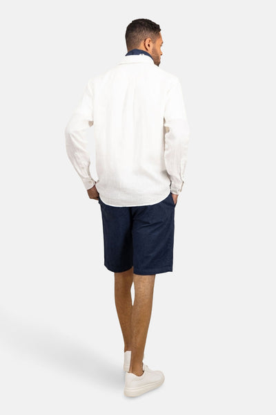 Chemise à manches longues blanche de FYNCH-HATTON, portée avec un short bleu marine et des baskets blanches, vue de dos.