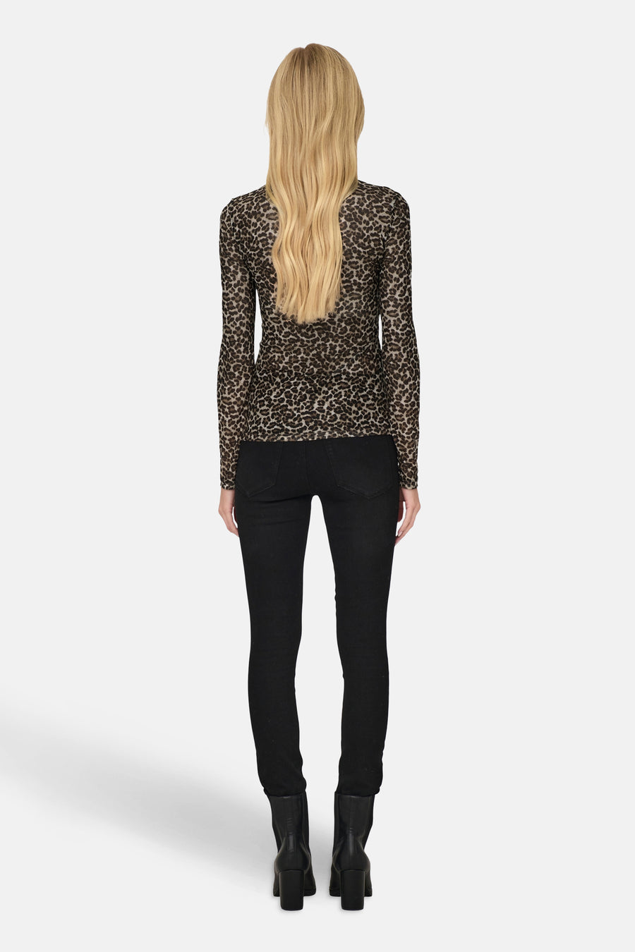 Pull col montant brun de ONLY, à motif léopard, porté avec un jean noir et des bottines à talons.
