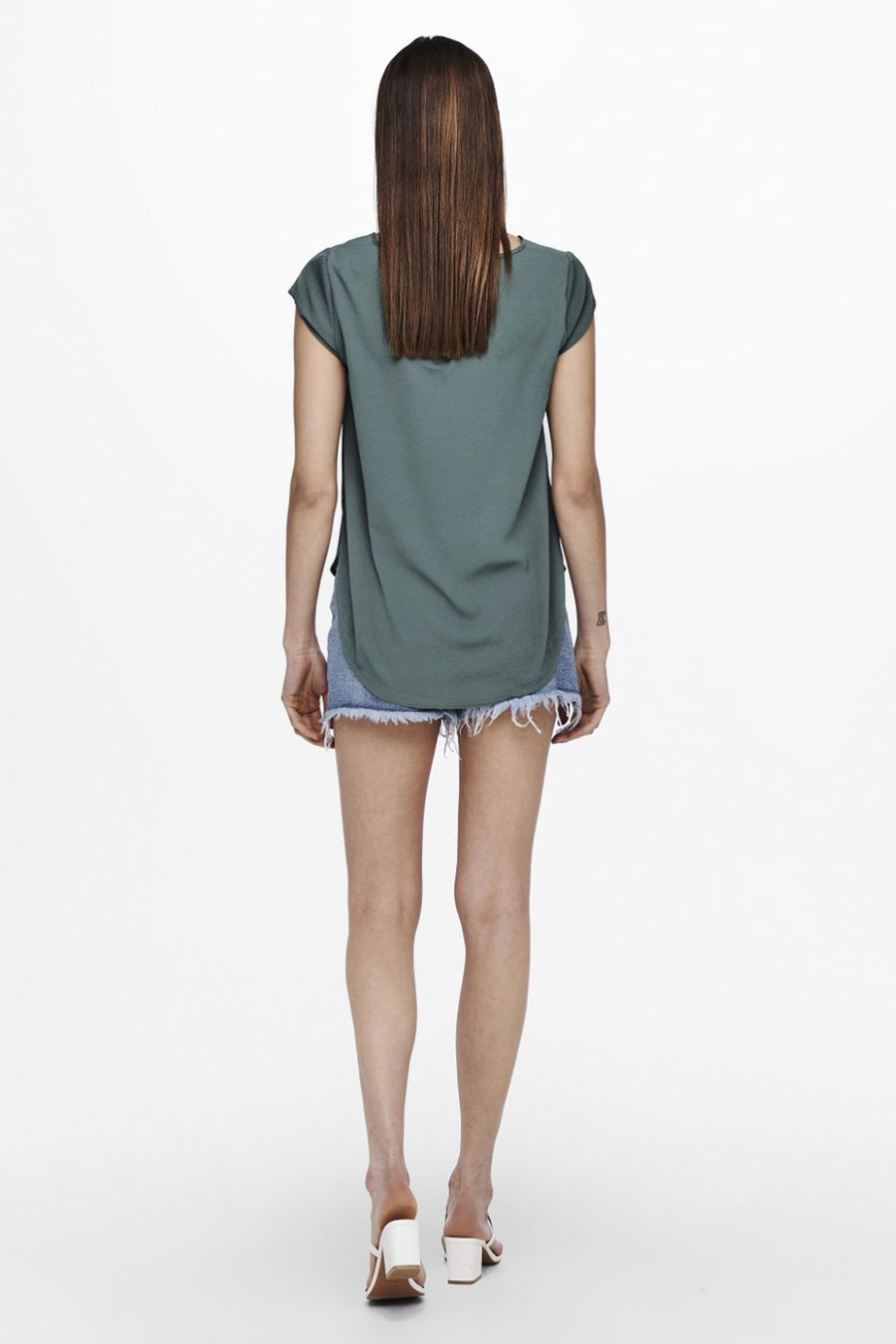 Blouse à manches courtes verte de ONLY, avec des manches courtes, portée avec un short en jean.