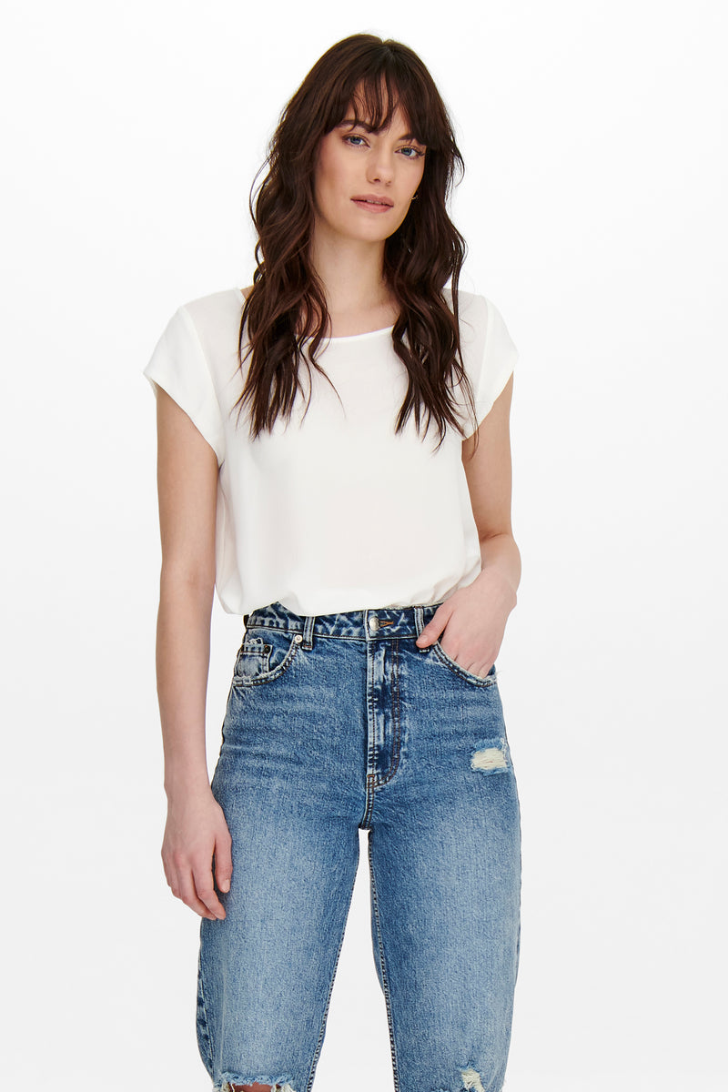Chemisier écru à manches courtes de ONLY®, porté avec un jean taille haute bleu délavé.
