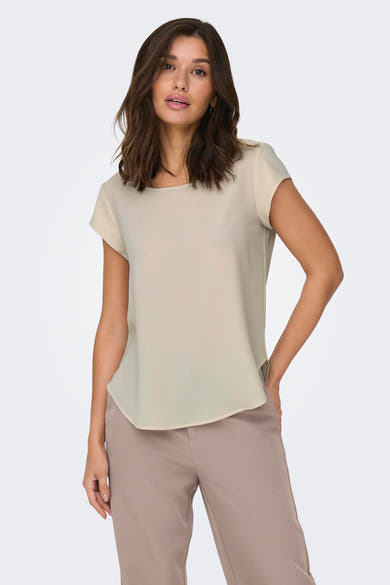 Blouse beige à manches courtes de ONLY, portée avec un pantalon taupe uni.
