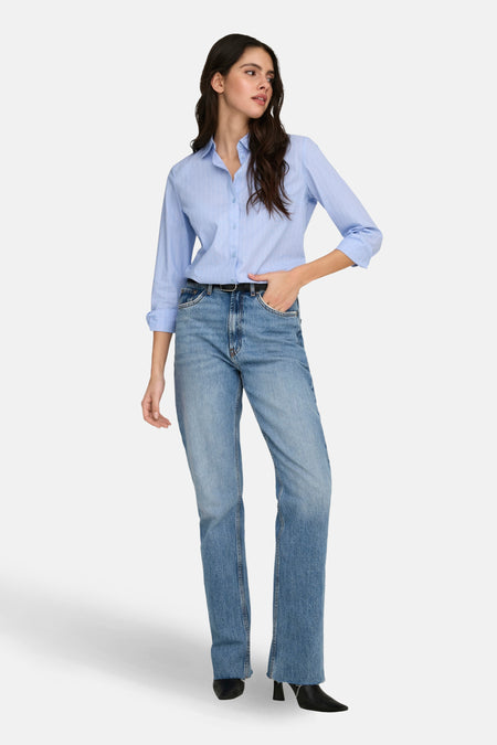 Chemise à manches longues bleue à rayures fines de JDY, portée avec un jean taille haute et des bottines noires.