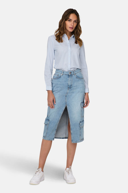 Chemise à manches longues bleue à rayures verticales de JDY, portée avec une jupe en jean fendue et des baskets blanches.