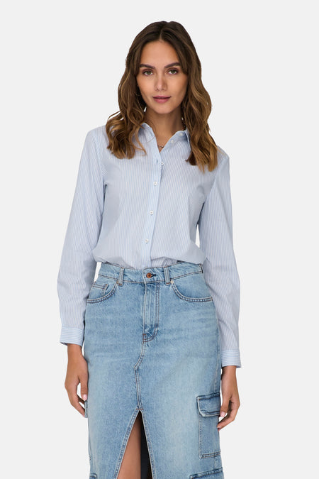 Chemise à manches longues bleue à rayures fines de JDY, portée avec une jupe en jean taille haute fendue.
