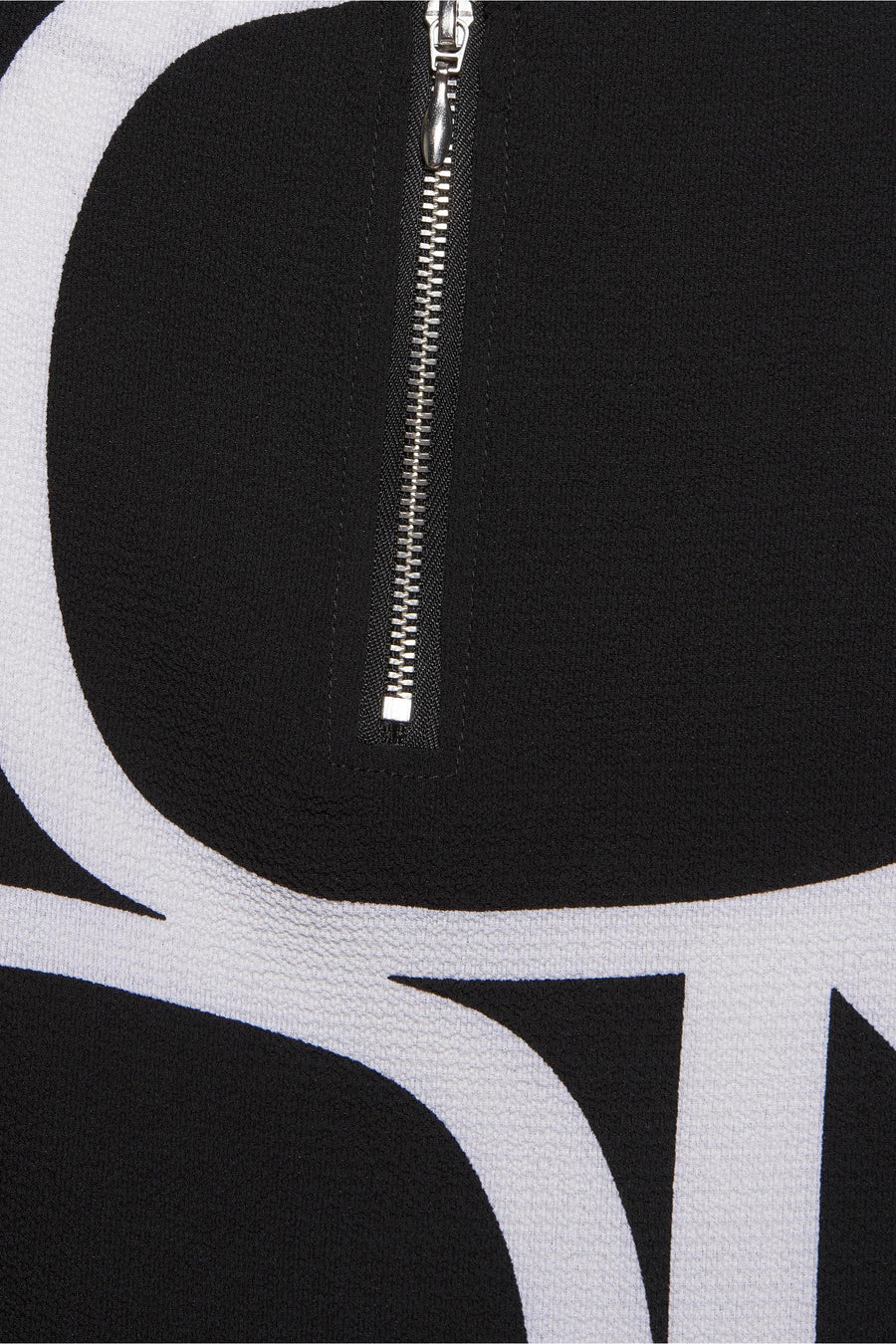 Blouse noire à manches courtes de ONLY®, avec motif graphique blanc et fermeture éclair argentée.
