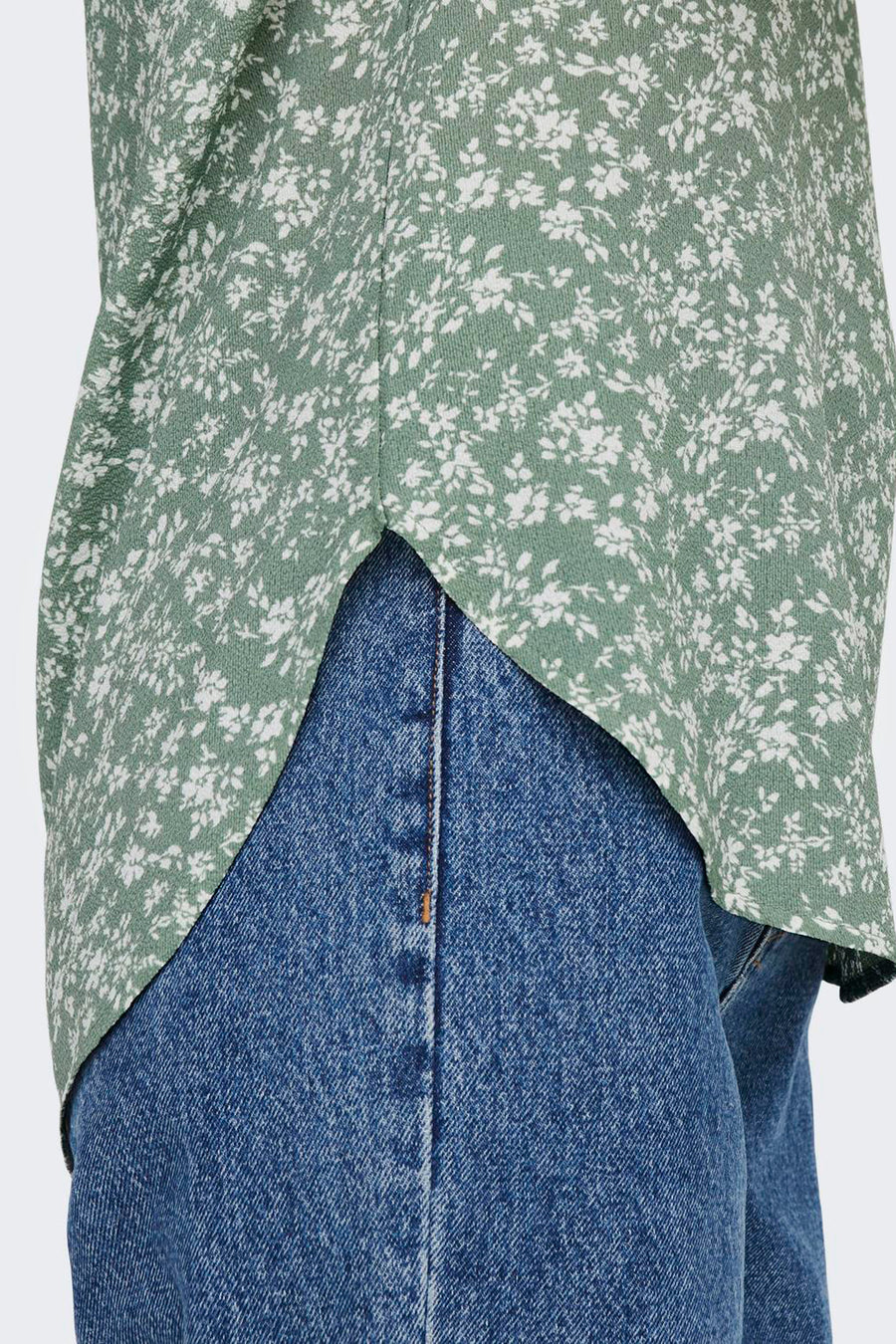 Blouse à manches courtes fleurie verte et blanche de ONLY®, portée avec un jean bleu.