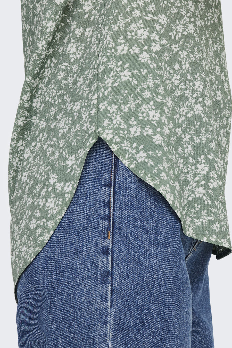 Blouse à manches courtes multicolore de ONLY®, avec motif floral sur un tissu vert doux, portée avec un jean bleu.
