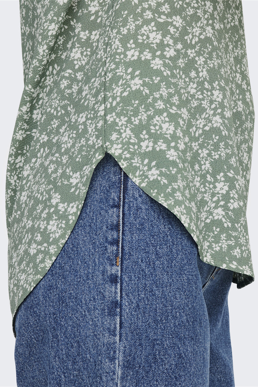 Blouse multicolore à manches courtes de ONLY, à motif floral sur fond vert, portée avec un jean bleu.
