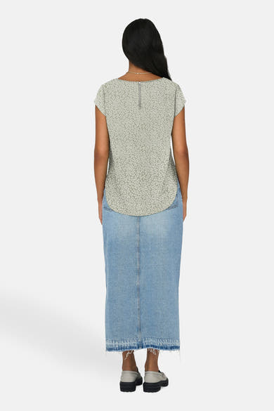 Chemisier vert à manches courtes de ONLY®, avec motif discret, porté avec une jupe longue en jean.