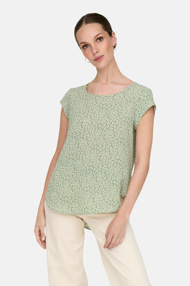 Chemisier vert à manches courtes de ONLY, imprimé de motifs floraux, porté avec un pantalon beige.
