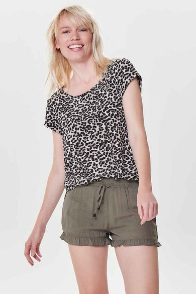 Blouse à manches courtes marron à motif léopard de ONLY®, portée avec un short kaki à volants.
