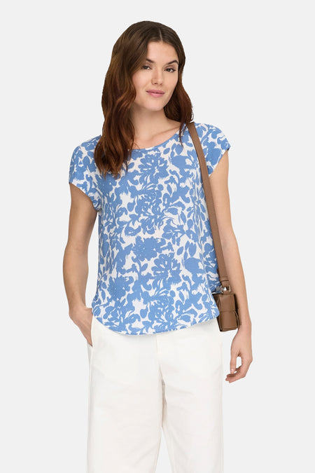 Chemisier bleu imprimé de ONLY®, porté avec un pantalon blanc et un sac à bandoulière marron