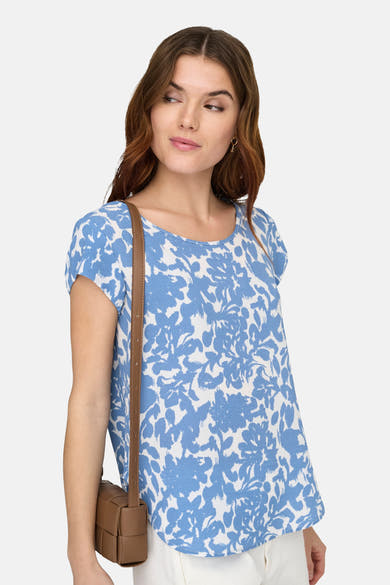 Blouse met korte mouwen in blauw en wit van ONLY, met bloemenprint en gedragen met een bruine tas.