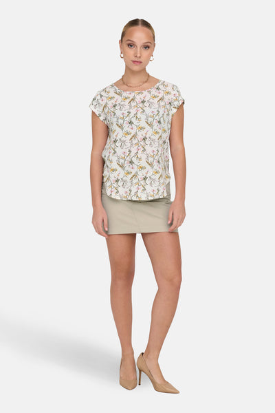 Chemisier à manches courtes par ONLY, avec un motif floral, porté avec une jupe kaki et des escarpins nude.
