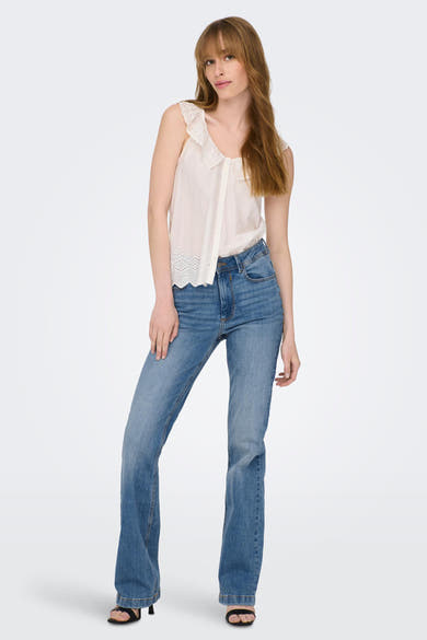 JDY blauwe flared jeans, gedragen met een witte kanten top en zwarte hak sandalen.