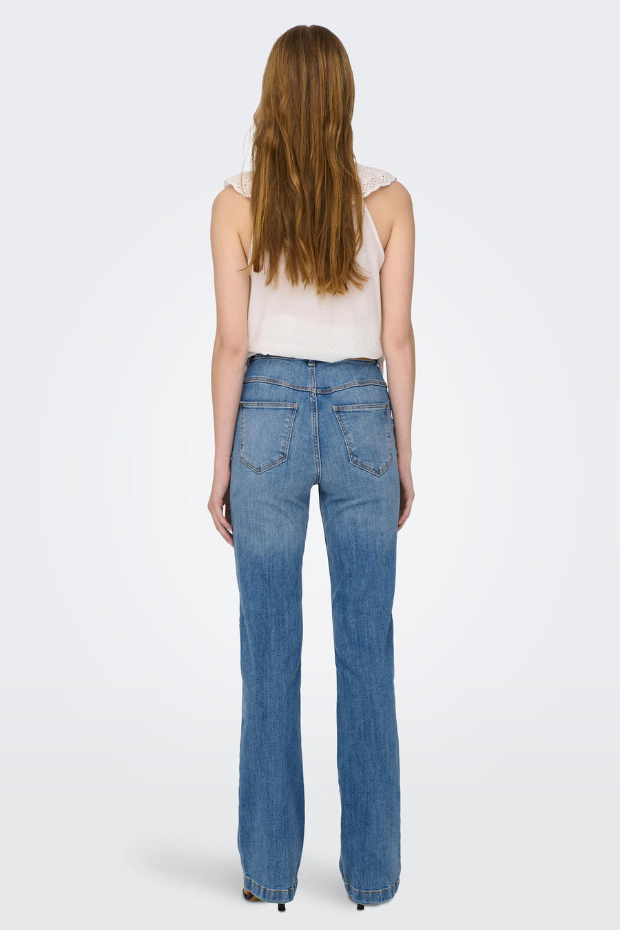 JDY blauwe flared jeans, van achteren gezien, gedragen met een mouwloze top.
