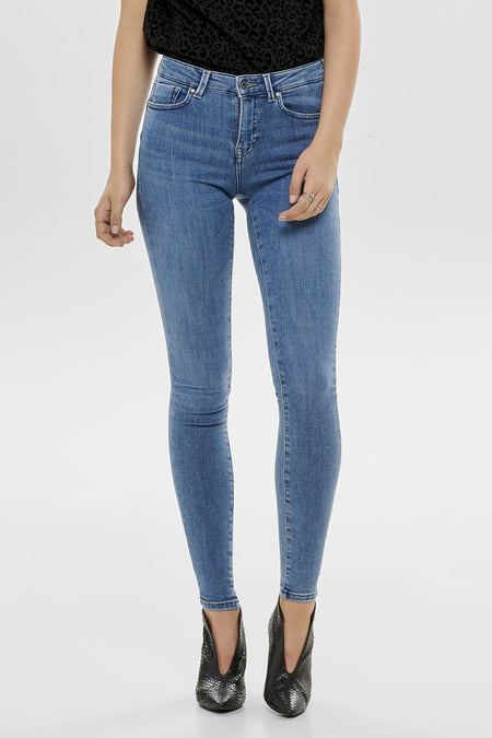 Jean skinny bleu de ONLY, porté avec un top à motif animalier et des chaussures noires à écailles.