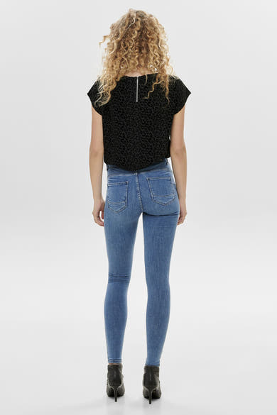 Blauwe skinny jeans van ONLY®, gedragen met een top met luipaardprint en naaldhak enkellaarsjes.