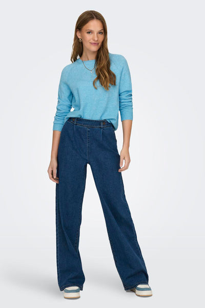 Pull bleu de ONLY, porté avec un pantalon large en jean et des baskets compensées.