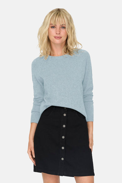 Pull à col rond bleu clair de ONLY®, porté avec une jupe noire boutonnée sur le devant.