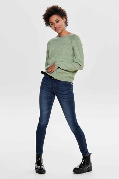 Pull col rond vert de ONLY, porté avec un jean bleu et des bottines vernies.