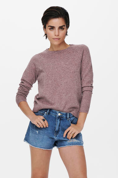 Pull à col rond rose de ONLY, porté avec un short en jean délavé et des bagues dorées.

