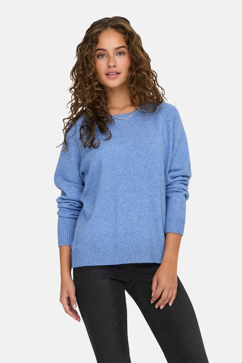 Pull bleu à col rond de ONLY, porté avec un pantalon noir.
