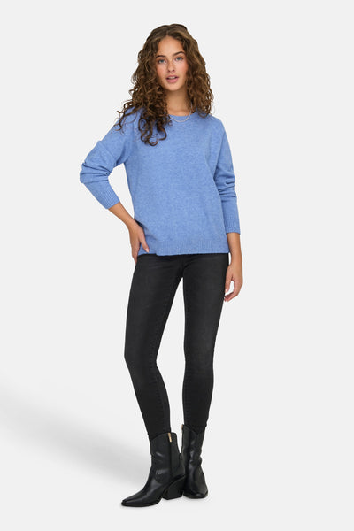 Pull à col rond bleu de ONLY, porté avec un jean noir et des bottes noires.
