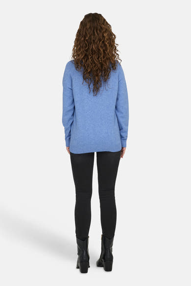 Pull à col rond bleu de ONLY®, porté avec un pantalon noir et des bottes en cuir.