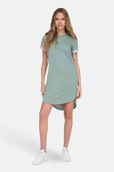 Groene jurk van JDY met korte mouwen en asymmetrische zoom, gedragen met witte sneakers.