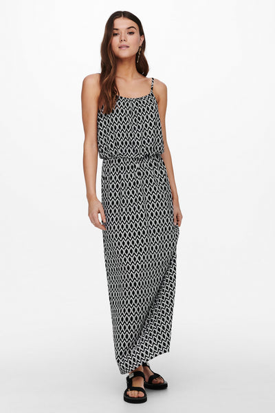 Robe midi noire ONLY, imprimé losanges contrastants, coupe fluide, portée avec des sandales noires à plateforme.