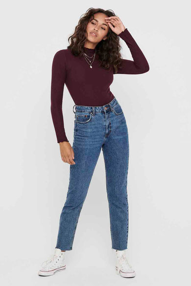 Pull à col rond bordeaux de ONLY, avec texture côtelée et porté avec un jean taille haute et des baskets montantes.
