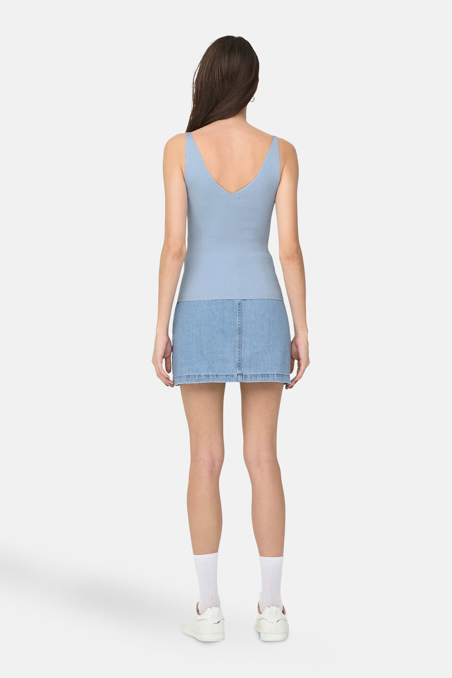Blauwe tanktop van JDY, halternek, gedragen met een spijkerrok en witte sneakers.