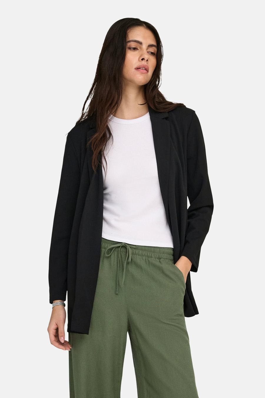 Zwarte blazer van JDY, gedragen over een wit T-shirt en een olijfgroene broek met trekkoord.